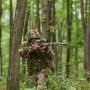 A highly skilled elite sniper, camouflaged in the dense forest, stealthily maneuvers through A highly skilled elite sniper, camouflaged in the dense forest, stealthily maneuvers through